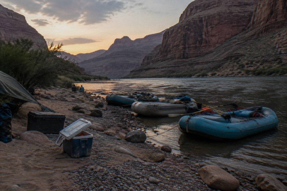 Rafts tied up at a sandy beach campsite along the Colorado River inside the Grand Canyon