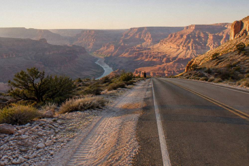 A desert road winding toward canyon ridges on the drive to Grand Canyon West